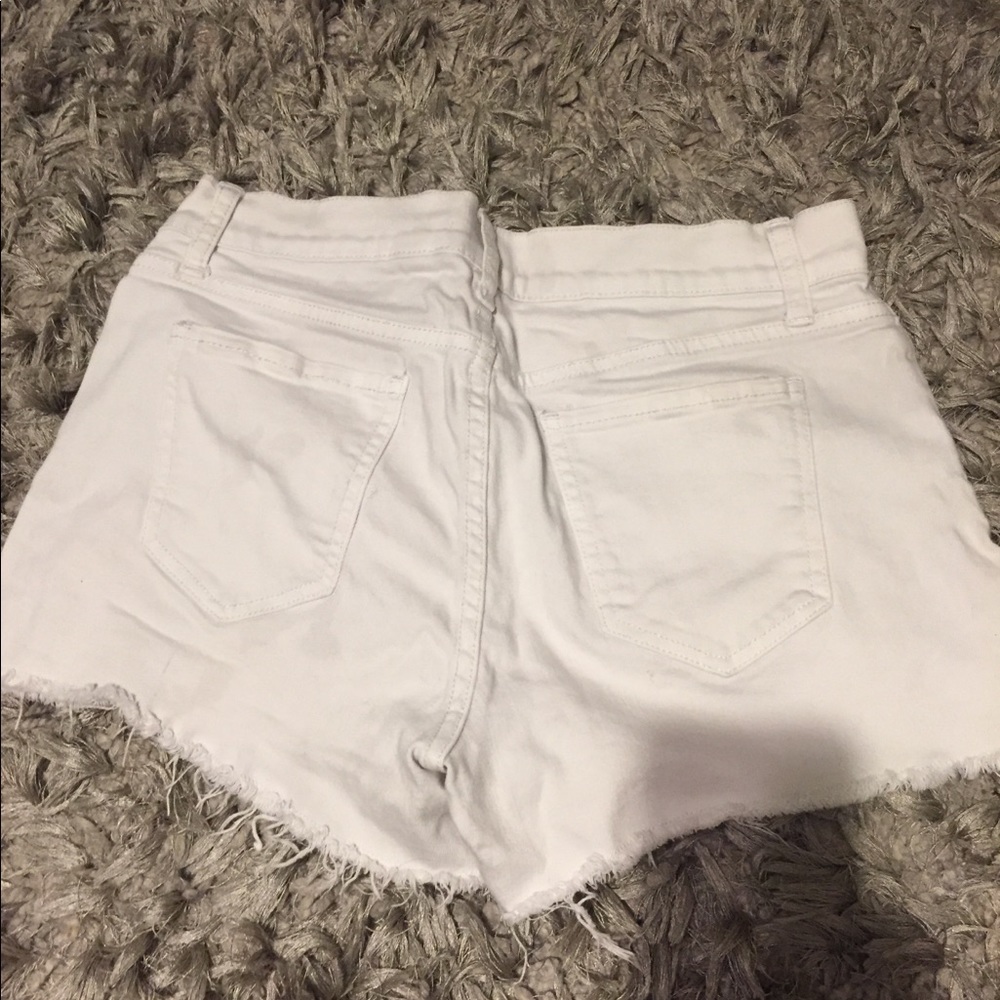 White jean shorts frayed at the bottom